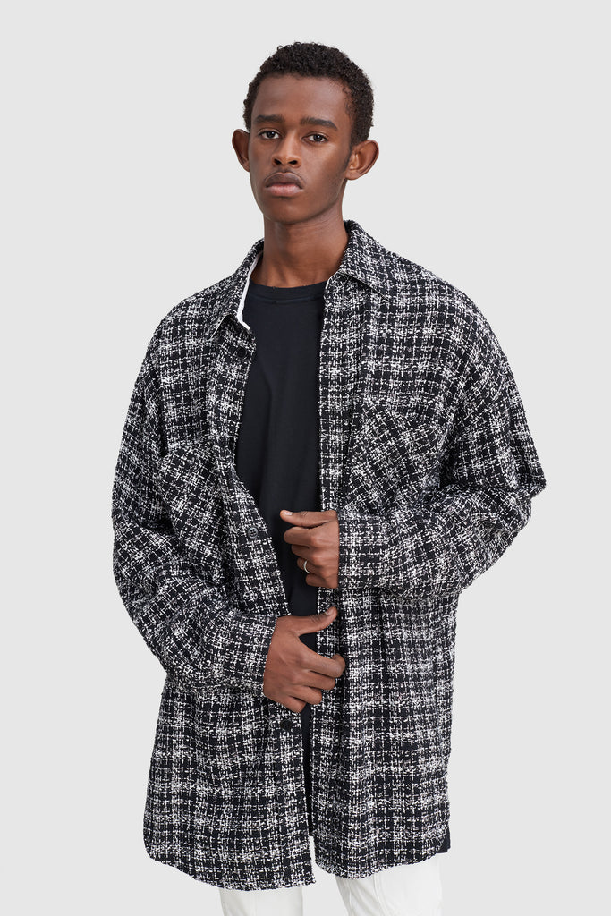 A man is wearing a black tweed oversize shirt by Faith Connexion, a brand of luxury clothes