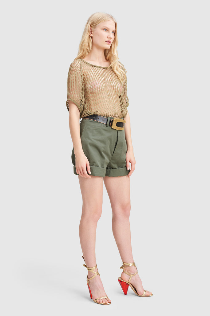 A woman is wearing a green khaki canvas shorts by Faith Connexion, a brand of luxury clothes